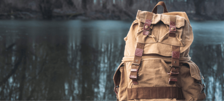 Rucksack am Wasser stehend